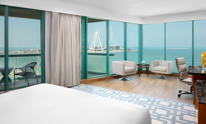 Suite met uitzicht op zee, groot bed, balkon, bureau en zitgedeelte